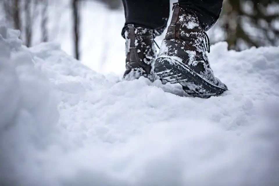 A winter boot stepping into deep, fresh snow
