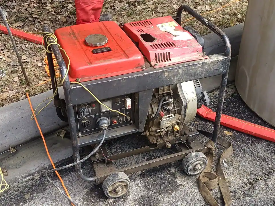 A portable generator outdoors with a cord plugged in